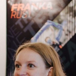 Franka Rust steht vor einer Wand mit Willke-Postern.